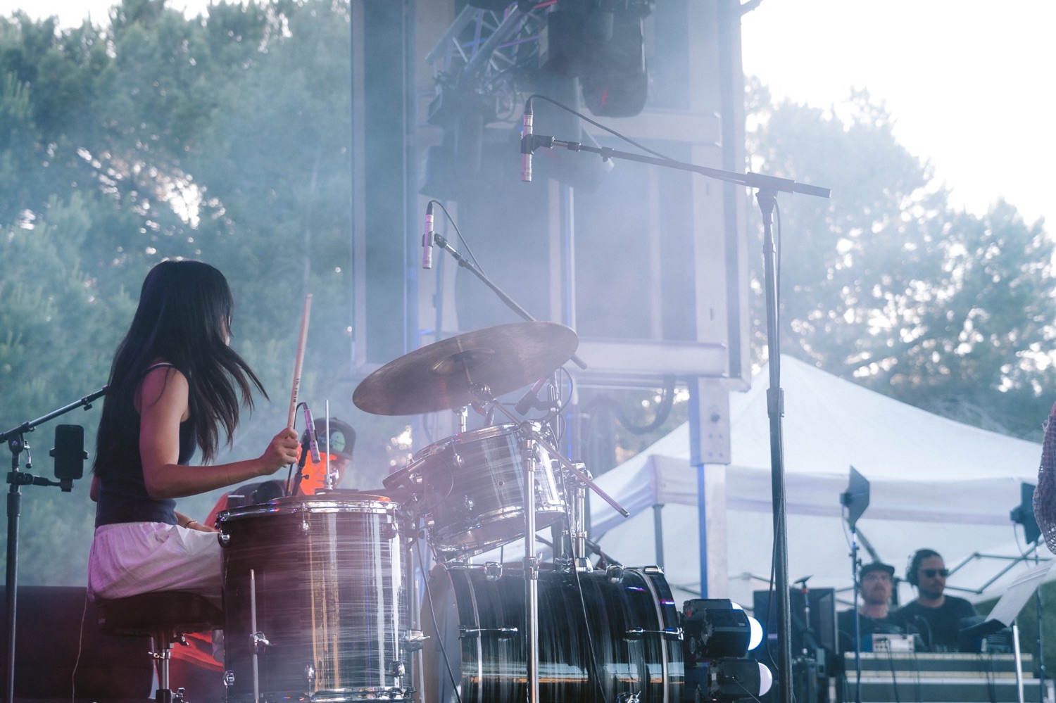 Tyan Lee playing drums on an outdoor festival stage